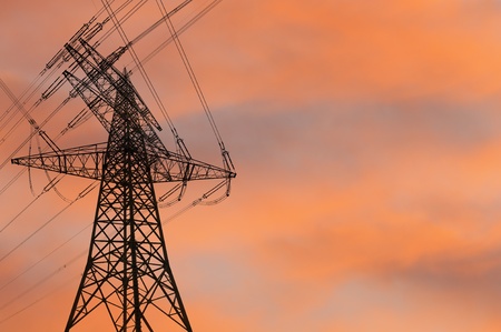 Electricity pylon silhouetted against the sunsetの写真素材