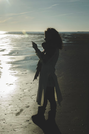 Woman looking at the mobile on a beach in Spain