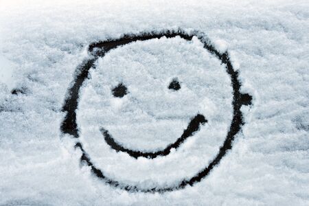 Smiley face drawn on snowの写真素材