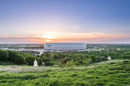 MUNICH, GERMANY - APRIL 29, 2018: Aerial view of Allianz Arena, the football stadium of FC Bayern, illuminated in red during sunset from Frtttmanninger Bergのeditorial素材