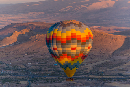 Colorful hot air balloon flying over the hills in Cappadocia, Turkeyの写真素材