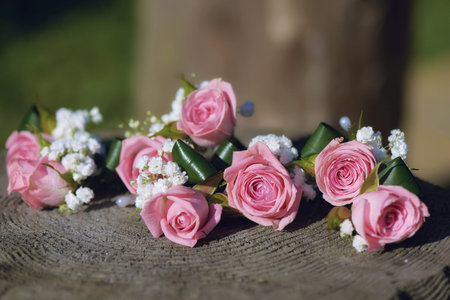Flower arrangement for wedding centerpiece featuring small pink roses and baby's-breath, positioned...