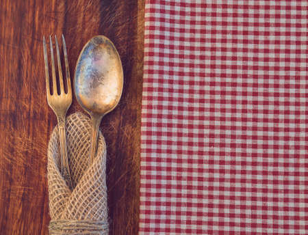 Vintage toned picture of the fork and spoon lying at the old table.の写真素材