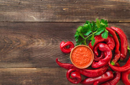 Homemade sauce and red hot chili peppers and celery on rustic wooden background. Top view.の写真素材