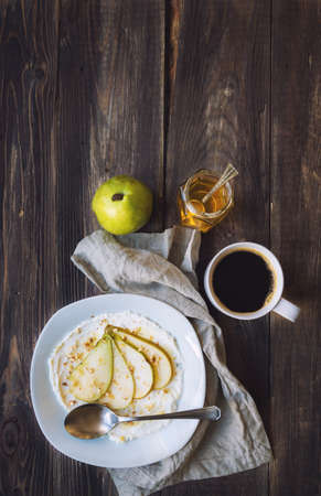 Ricotta cheese with pear,crushed walnuts and honey on rustic wooden background. Healthy breakfast. Top view.の写真素材