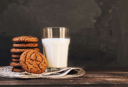 Chocolate cookies with milk on dark concrete background. Selective focus.の写真素材