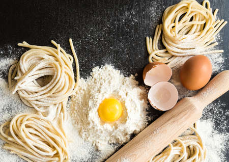 Raw homemade pasta with ingredients on black background. Top view.の写真素材