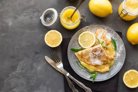 Fresh homemade crepes with lemon curd on grey concrete background. Top view.の写真素材
