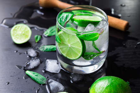 Mojito cocktail with lime, mint leaves and ice cubes on blackの写真素材