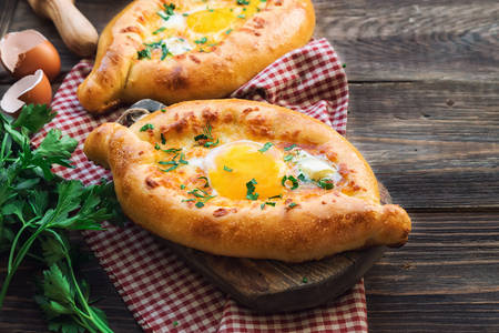 Fresh homemade khachapuri Ajarian on rustic woodenの写真素材