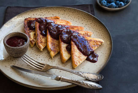 French toasts with blueberry jam on gray concrete background. Selective focus.の写真素材