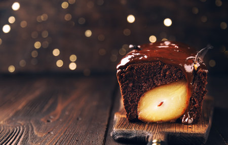 Homemade chocolate cake with pear at rustic wooden background with bokeh. Christmas brownie with fudge. Selective focus.の写真素材
