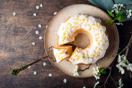 Fresh homemade lemon bundt cake decorated with white glaze and zestの写真素材
