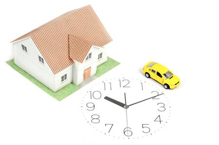 Toy car and house on clock faceの写真素材