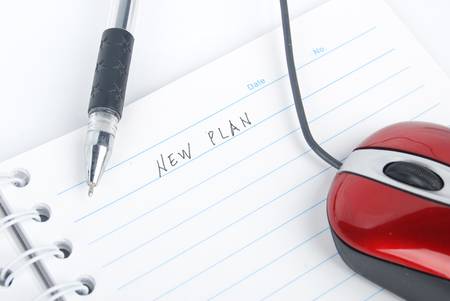 Computer mouse and notepad with penの写真素材