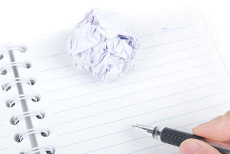 Crumpled paper ball and notepad with penの写真素材