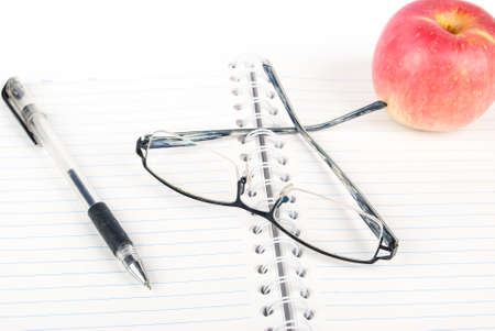 Apple,glasses and pen on notepadの写真素材