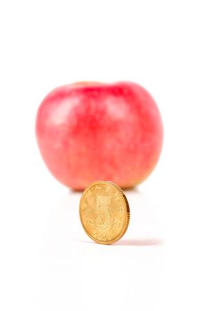 Apple with coins on white backgroundの写真素材
