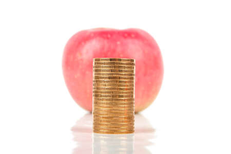 Apple with coins on white backgroundの写真素材