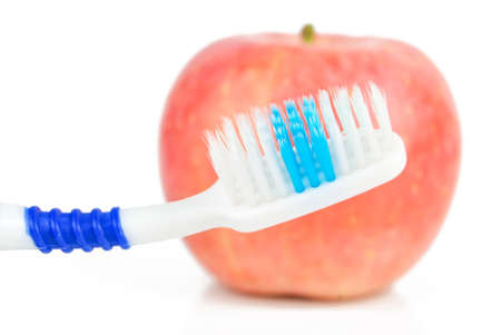 Apple and toothbrush on white backgroundの写真素材