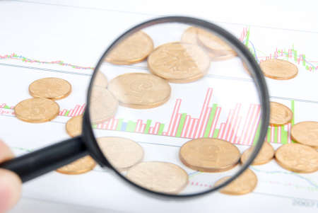 Magnifier and coin on stock chartの写真素材