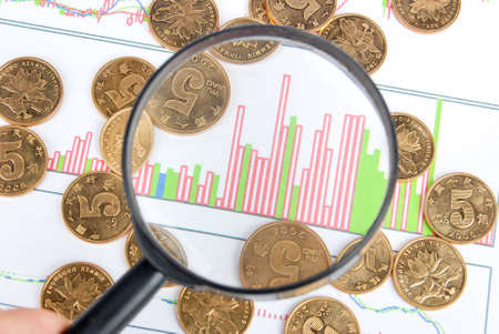 Magnifier and coin on stock chartの写真素材