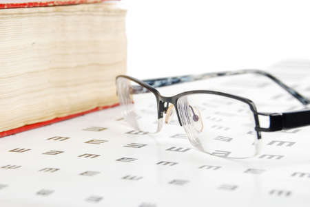 Glasses and dictionary with eye chartの写真素材