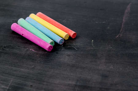 Row of color chalk on a blackboardの写真素材