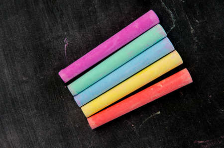 Row of color chalk on a blackboardの写真素材