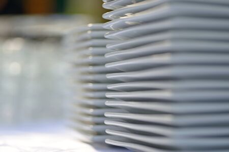 Prepared clean dishes for dinner party on a table in the kitchenの写真素材