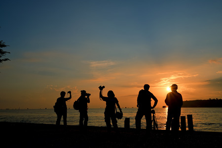 silhouette group of cameraman or photographer with sunset lightの写真素材