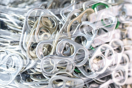 aluminum pull tabs in blastic bottle on white blackgroundの写真素材