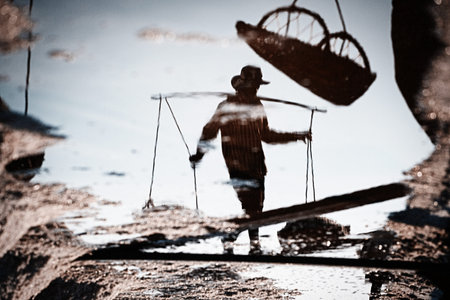 Salt farmers carry salt into the shed.
