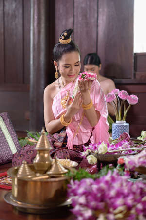 Thai women in Thai traditional dress are decorating flowers.の写真素材