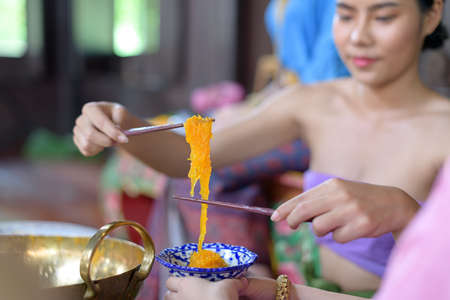 Thai people make Thai dessert in Thai period costumeの写真素材
