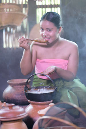 Thai woman cooking in retro Thai dressの写真素材