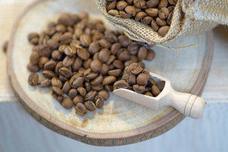 Close-up of roasted coffee beans in a cup on a table.の写真素材