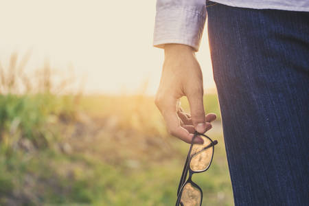 a man holding glasses on sunset.の写真素材