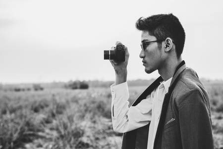 A man holding camera to a shot.の写真素材