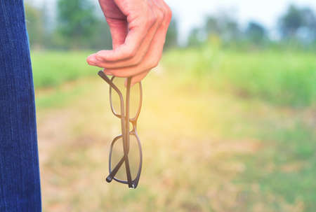 Man holding glasses on grassの写真素材