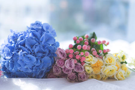 Image of beautiful spray yellow and violet roses, blue hydrangea, pink hypericum on light background. Flowers bouquet recipeの写真素材