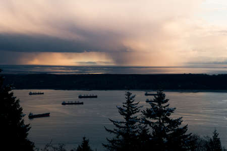 Ocean with cargo ships and rain from cloudsの写真素材