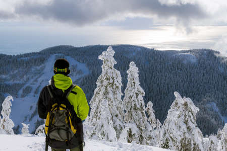 Winter seascape with island, mountains in snow and cloudsの写真素材
