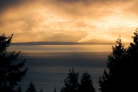 Ocean with cargo ships and rain from clouds