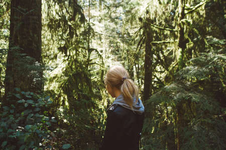 Green rainforest with woman walking throughの写真素材