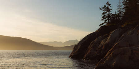 Golden hour on shore with rocks and oceanの写真素材