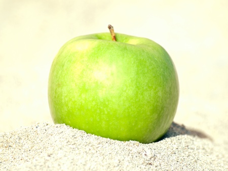 green apple on sandの写真素材