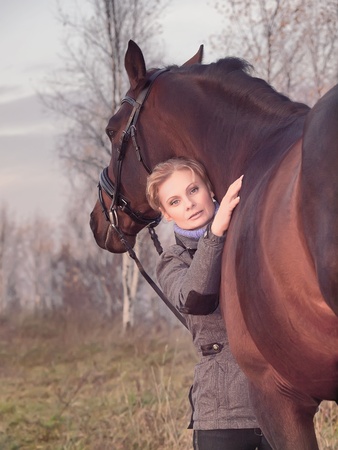 women with her horse at evening の写真素材