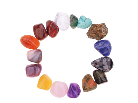 Color spectrum of semiprecious gemstones in circle frame, on white background 