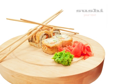 sushi rolls with omelette and eel and chopsticks on desk over whiteの写真素材